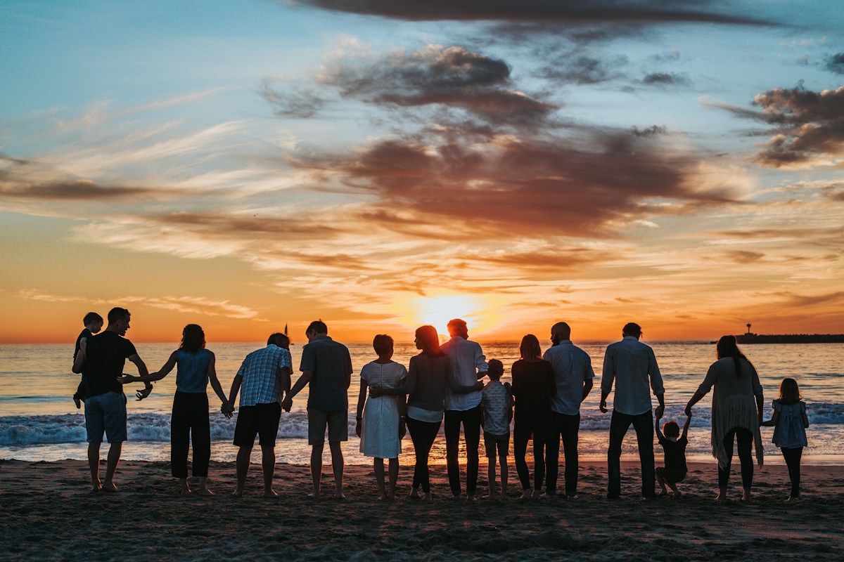 Family members holding hands together at the beach