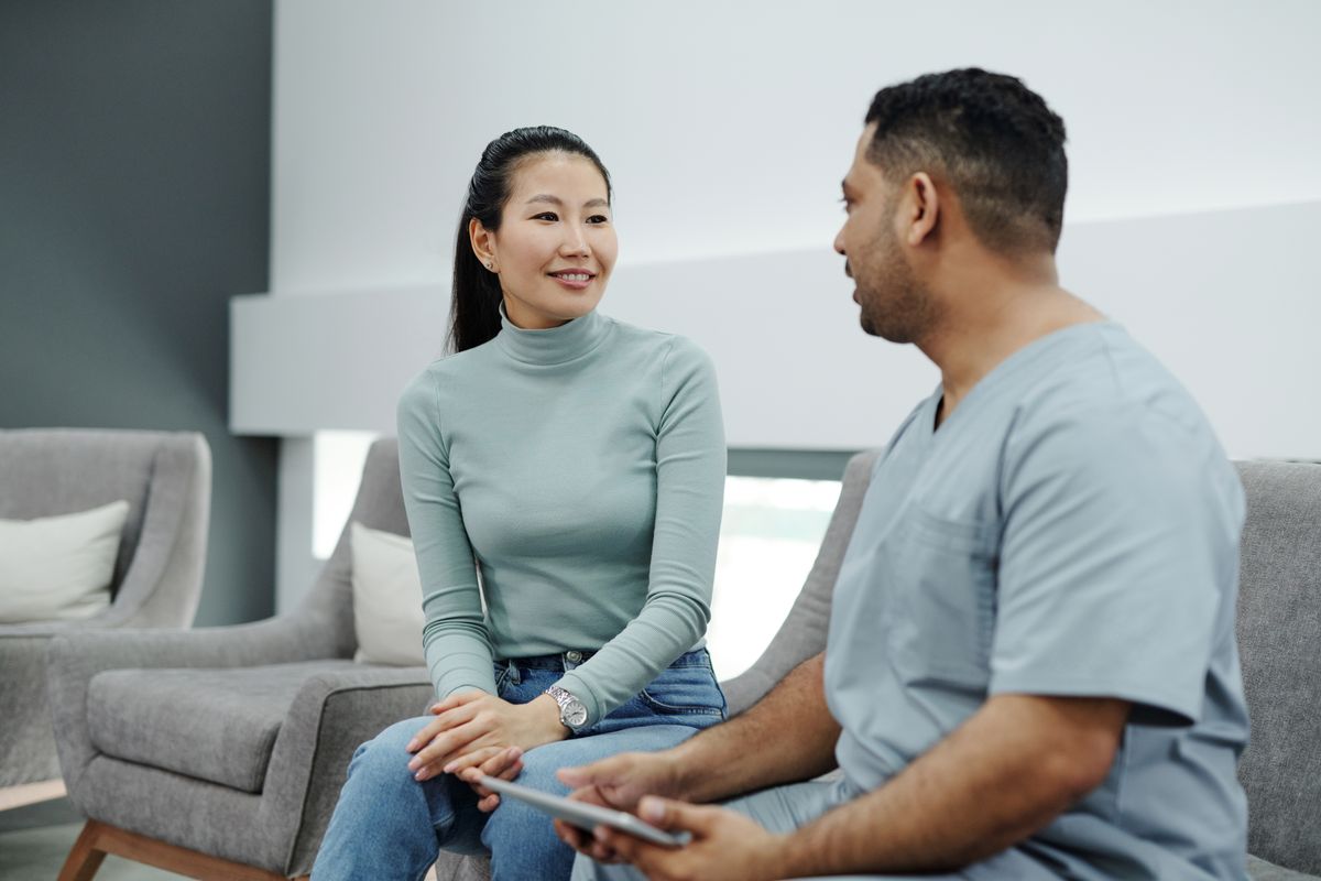 A healthcare professional talking with a patient during a consultation